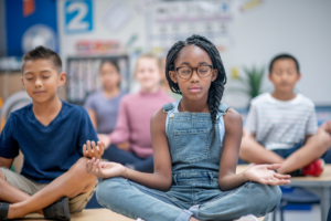 Child sitting cross legged with eyes closed