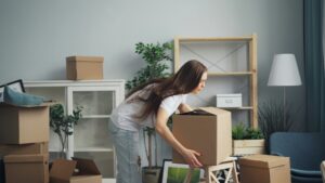 Young person lifting a moving box.