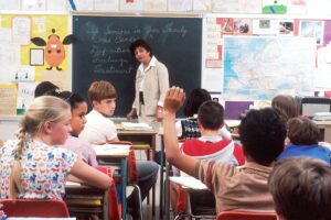 Child raising hand in a classroom
